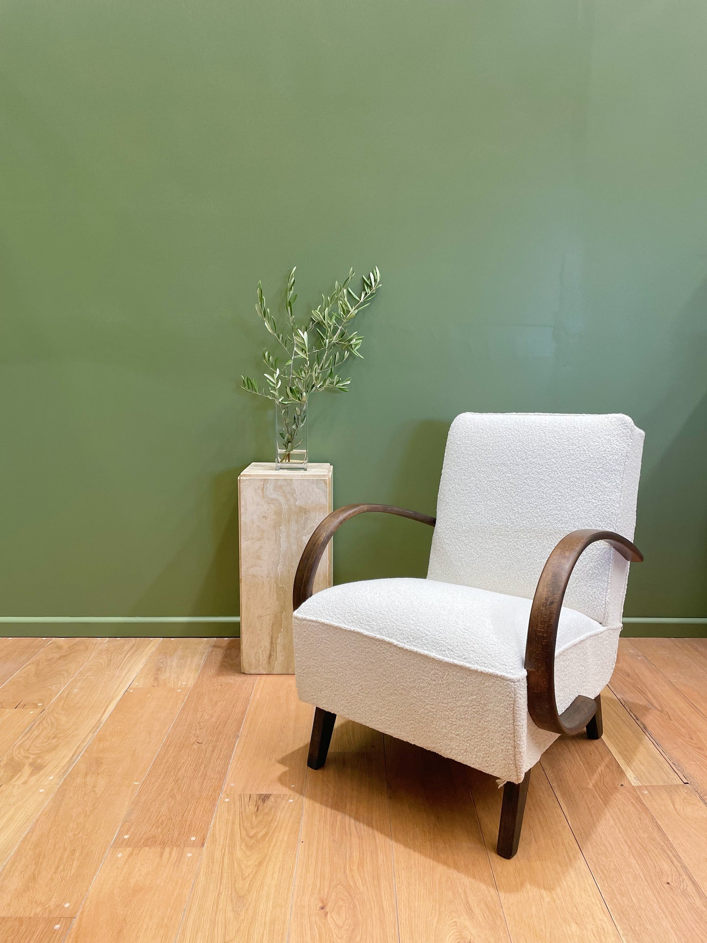 Reupholstered Halabala chair with green wall